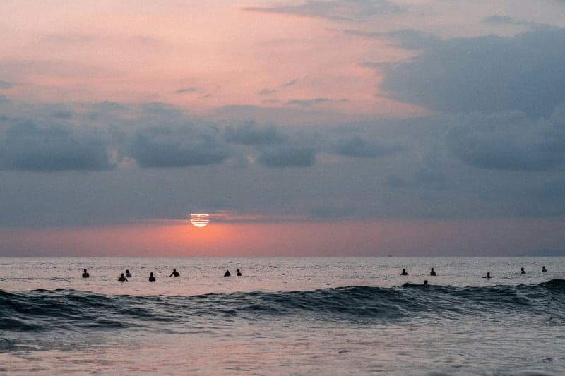 View of a sunset with surfers in Jacó Beach, Pacific of Costa Rica